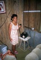 Fotografía de una señora con un radio en la mano en el Puesto Alto Tigre  Jiménez Osa  Puntarenas. Trabajo voluntario de monitoreo de la red de comunicación que realizan en los puestos de radio que se ubican en las partes altas de las montañas de nuestro país que son atendidos en su mayoría por indígenas